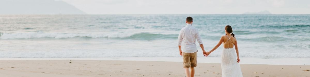 Wedding couple on the beach holding hands 